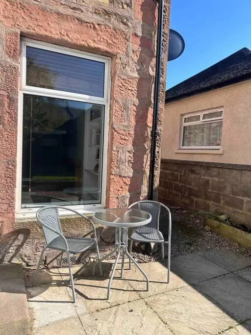 a table and two chairs sitting next to a window at Home Sweet Home, Central in Inverness