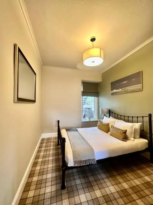 a bedroom with a bed and a window in it at Home Sweet Home, Central in Inverness