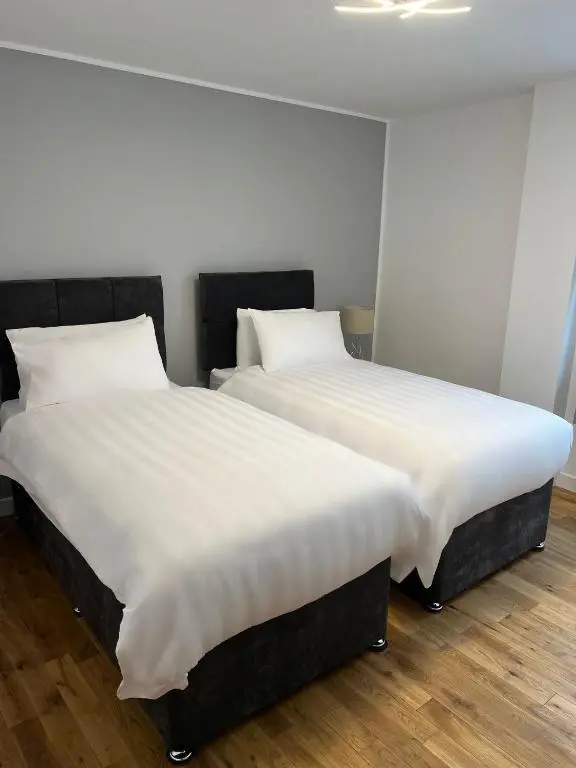 two beds sitting next to each other in a room at Inverness Highland Apartment in Inverness