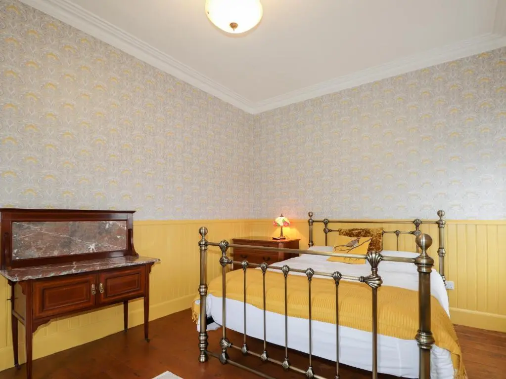 a bedroom with a bed and a dresser and a desk at Station House in Lybster