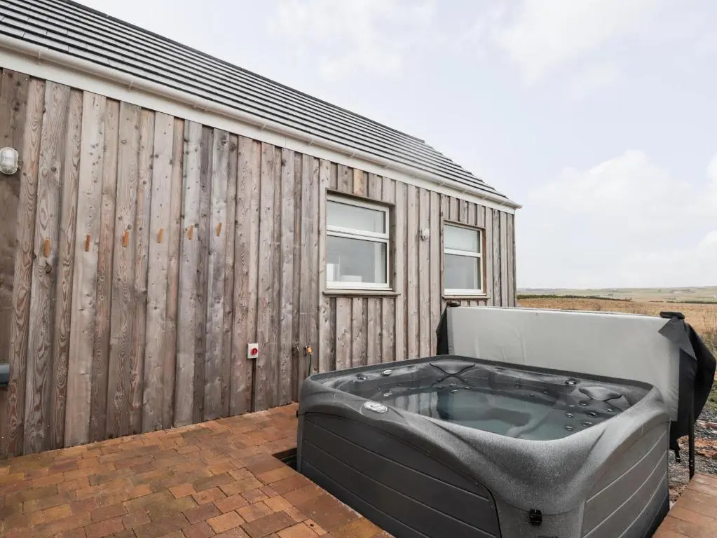 a bath tub sitting on a deck next to a building at Station House in Lybster