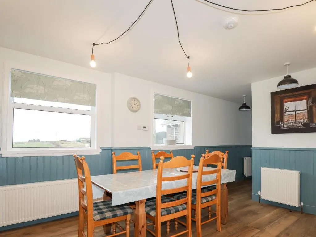 a dining room with a table and chairs at Station House in Lybster