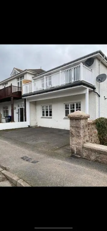 a large white house with a balcony on a street at 1 Golf Mews in Ballater
