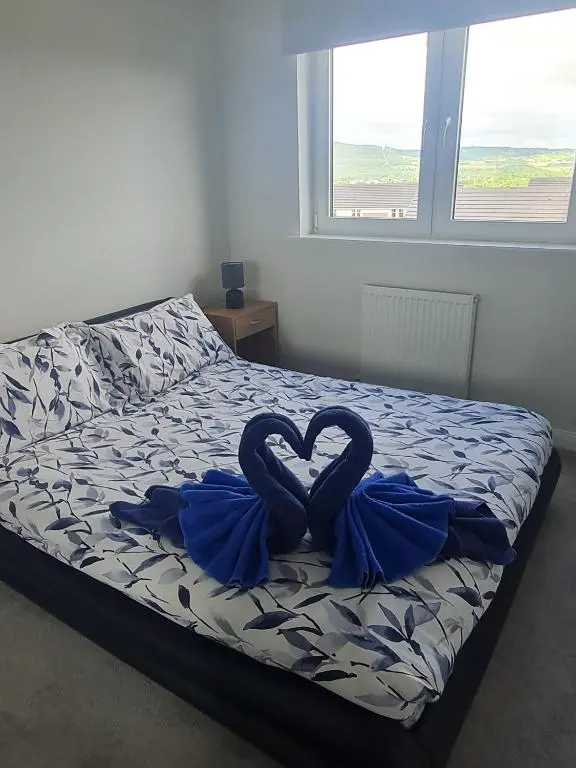 a bed with two swans in the shape of a heart at Faillie in Inverness